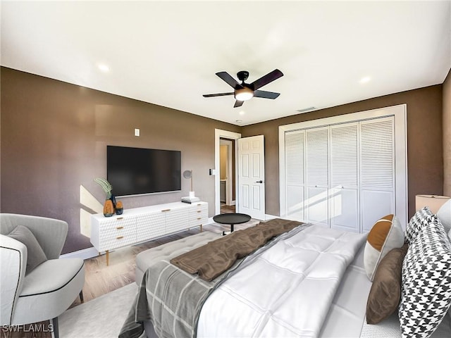 bedroom with wood-type flooring, a closet, and ceiling fan