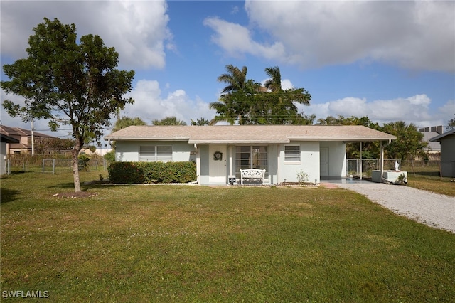 ranch-style house featuring a front lawn and a carport