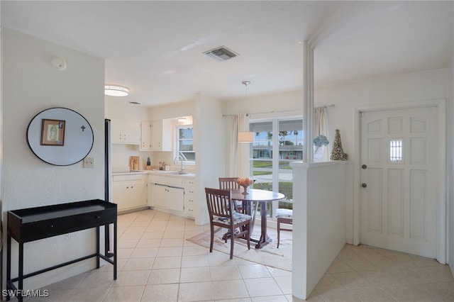 kitchen with light tile patterned flooring, white cabinetry, and sink