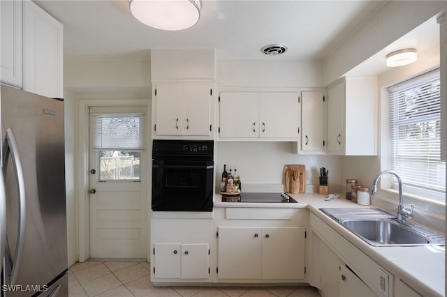 kitchen featuring black appliances, white cabinets, and sink