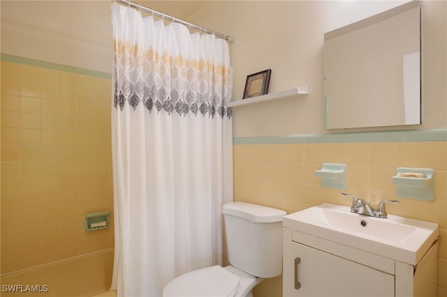 full bathroom with vanity, toilet, tile walls, and shower / tub combo