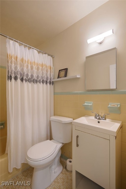 full bathroom featuring vanity, toilet, tile walls, and shower / bath combo with shower curtain