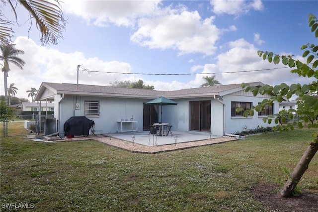 back of property with a patio area and a lawn