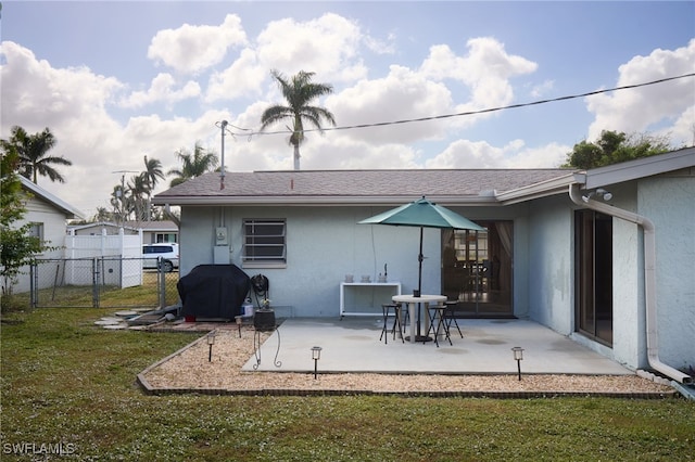 rear view of property featuring a yard and a patio