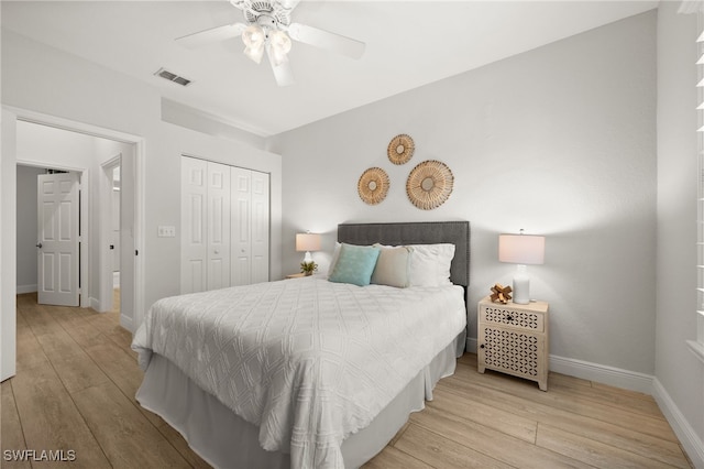 bedroom with a closet, light hardwood / wood-style flooring, and ceiling fan