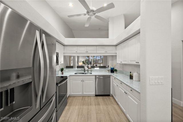 kitchen featuring ceiling fan, sink, light hardwood / wood-style flooring, stainless steel appliances, and white cabinets