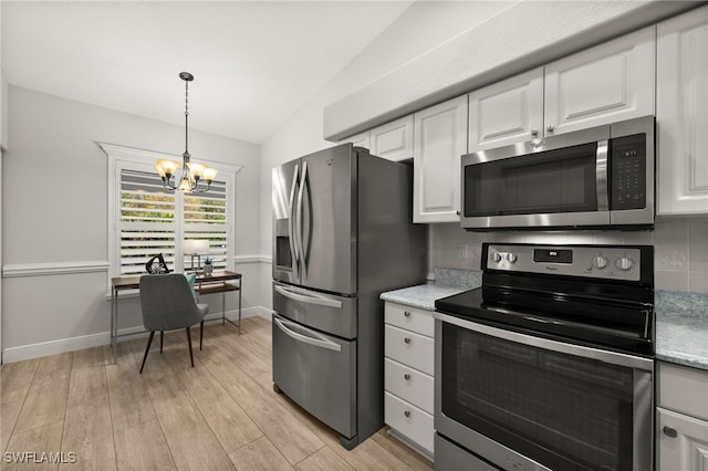 kitchen featuring white cabinets, a notable chandelier, stainless steel appliances, and light hardwood / wood-style floors