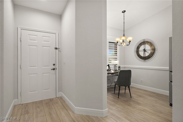 entrance foyer with an inviting chandelier and light hardwood / wood-style flooring