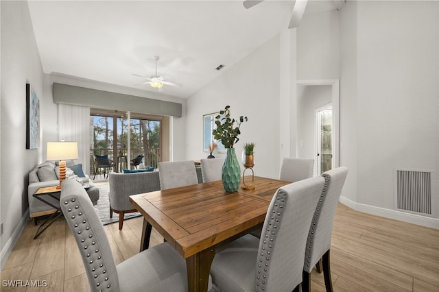 dining room featuring ceiling fan, light hardwood / wood-style floors, and vaulted ceiling