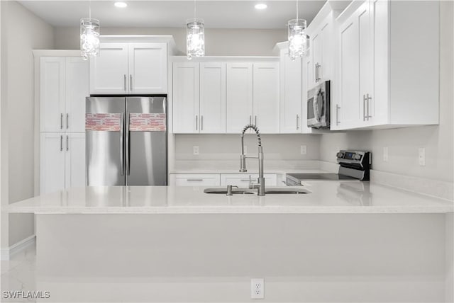 kitchen with white cabinets, appliances with stainless steel finishes, decorative light fixtures, and sink