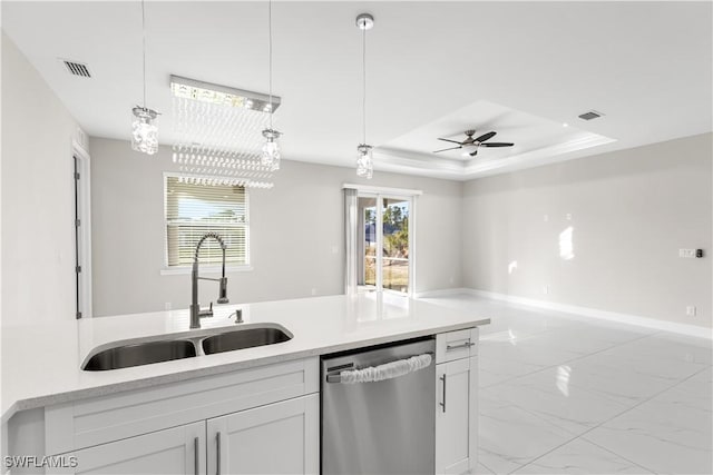 kitchen with white cabinetry, stainless steel dishwasher, a tray ceiling, and sink