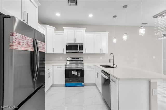 kitchen with white cabinetry, sink, stainless steel appliances, and decorative light fixtures