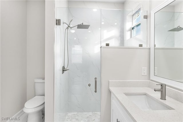 bathroom featuring vanity, toilet, and a shower with shower door