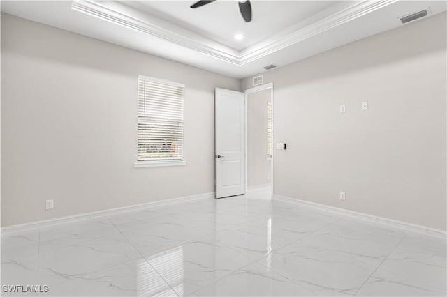 empty room featuring a tray ceiling, ceiling fan, and ornamental molding