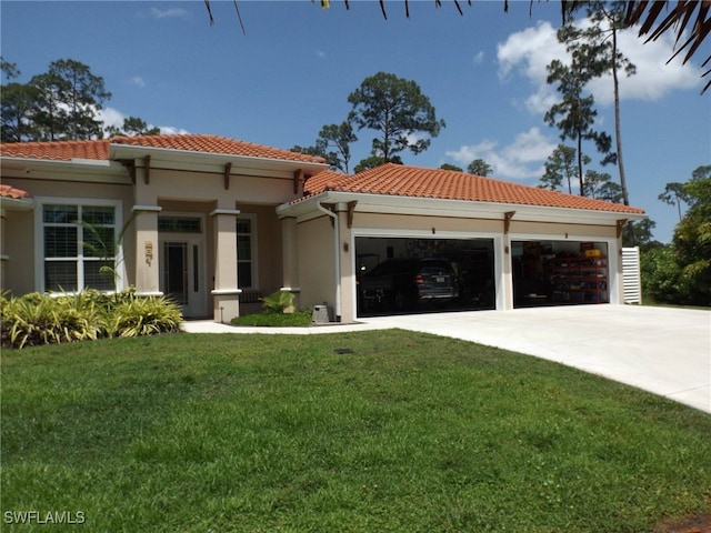 mediterranean / spanish home with a garage and a front lawn