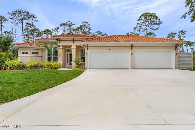 mediterranean / spanish-style house with a garage and a front lawn