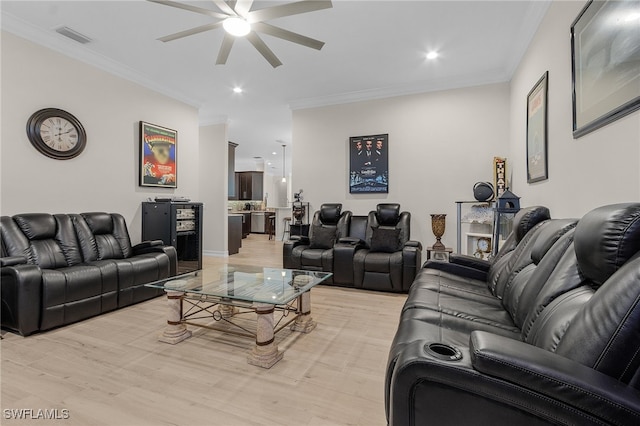 living room featuring light hardwood / wood-style floors, ceiling fan, and crown molding