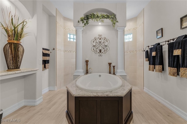 bathroom featuring wood-type flooring, independent shower and bath, and ornate columns