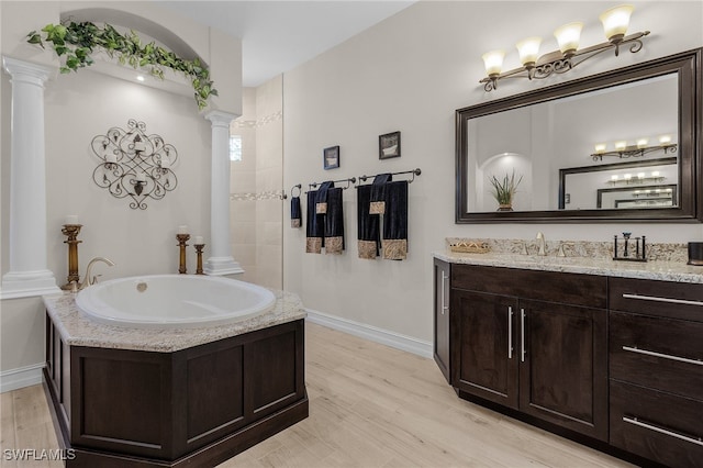 bathroom with hardwood / wood-style floors, vanity, and ornate columns