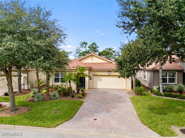 mediterranean / spanish-style home with a front lawn and a garage