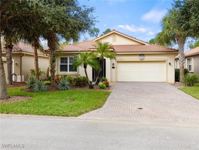 mediterranean / spanish-style home with a garage and a front lawn