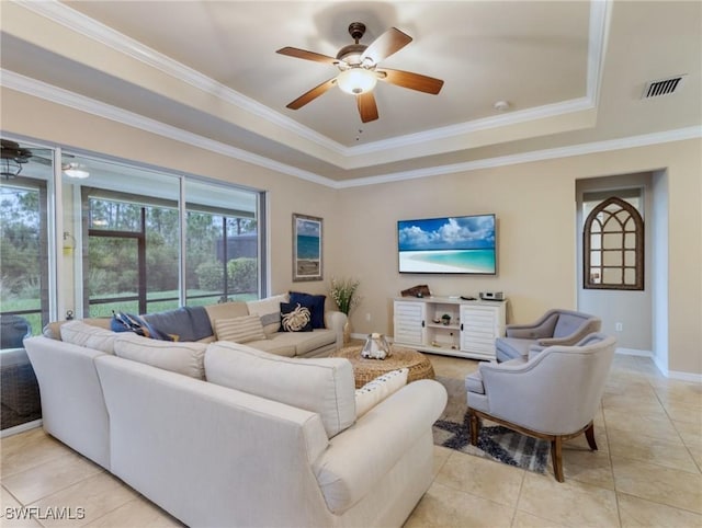 tiled living room featuring ceiling fan, a raised ceiling, and ornamental molding