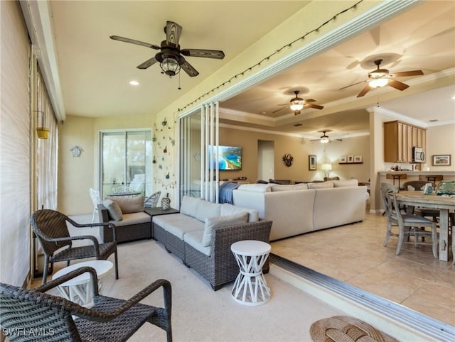 living room with a raised ceiling and crown molding