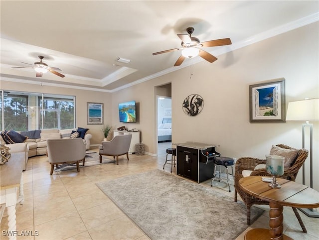 tiled living room featuring a tray ceiling, ceiling fan, and crown molding