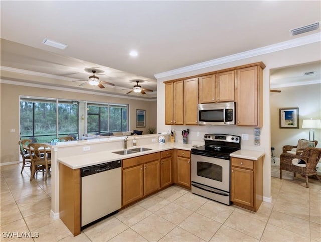 kitchen featuring kitchen peninsula, sink, ornamental molding, and appliances with stainless steel finishes