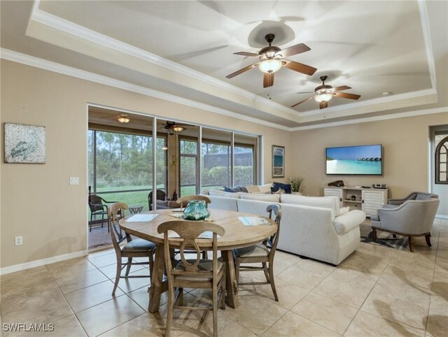 tiled dining room featuring ceiling fan, a raised ceiling, and ornamental molding