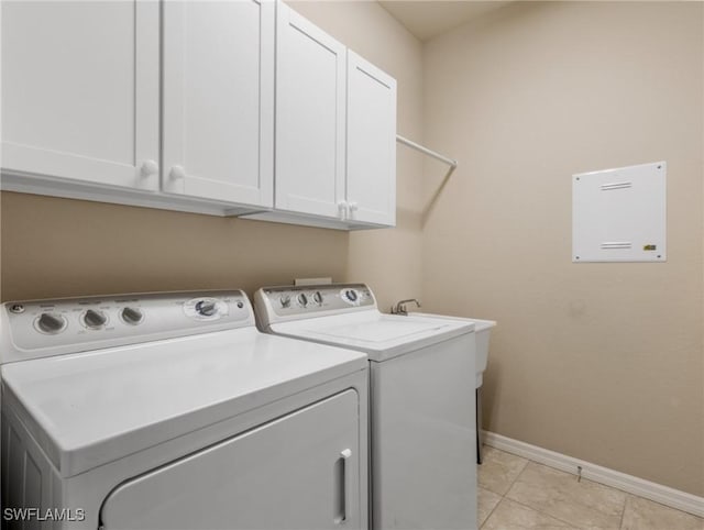 laundry room with cabinets, light tile patterned floors, and washer and clothes dryer