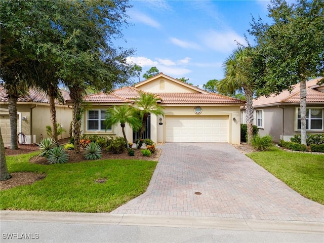 mediterranean / spanish home with a front yard and a garage