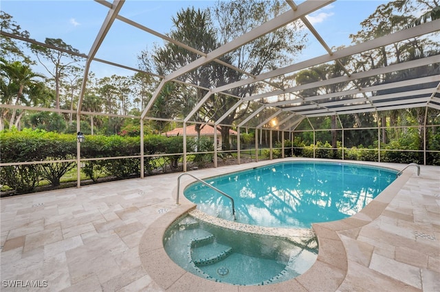 view of swimming pool with glass enclosure, an in ground hot tub, and a patio