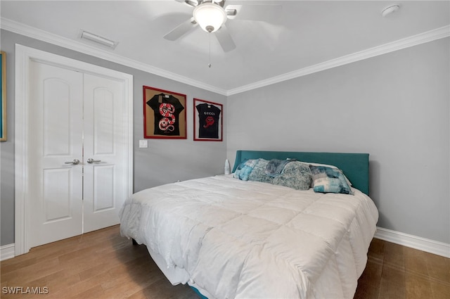 bedroom with ceiling fan, a closet, crown molding, and hardwood / wood-style flooring