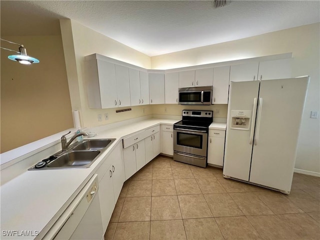 kitchen featuring light tile patterned flooring, white cabinetry, sink, stainless steel appliances, and a textured ceiling