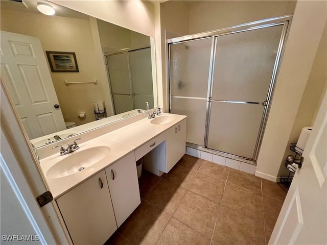 bathroom featuring an enclosed shower, vanity, tile patterned floors, and toilet