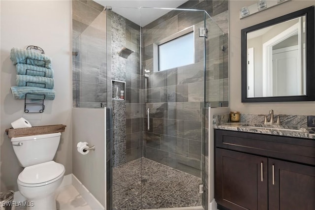 bathroom with walk in shower, vanity, and toilet