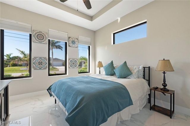 bedroom featuring ceiling fan and a tray ceiling