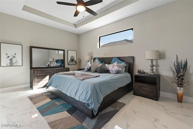 bedroom with a tray ceiling and ceiling fan