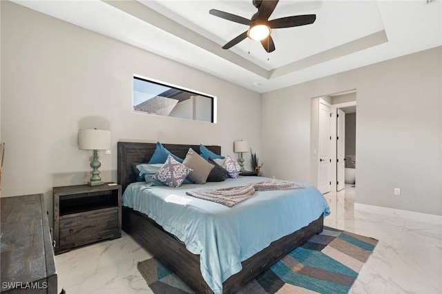 bedroom with a tray ceiling and ceiling fan