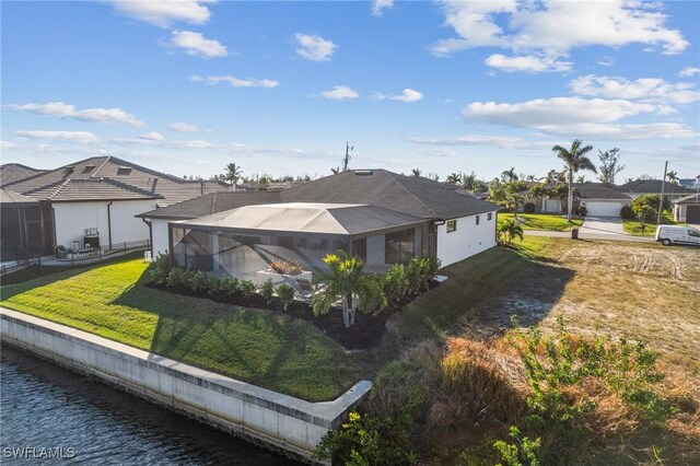 exterior space with glass enclosure, a water view, and a front yard