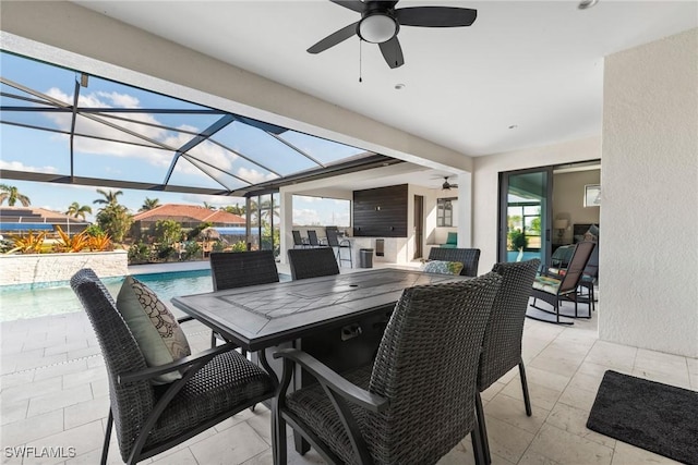 view of patio featuring ceiling fan, area for grilling, and a lanai