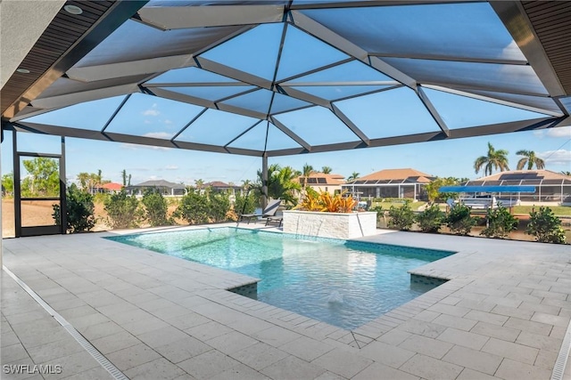 view of pool featuring pool water feature, a patio area, and a lanai