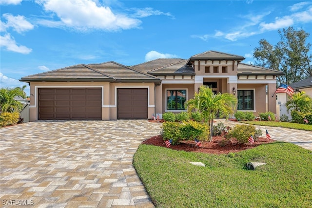 605 SW 39th Ave, Cape Coral, FL 33991 - prairie-style house with a garage, decorative driveway, stucco siding, and a front lawn