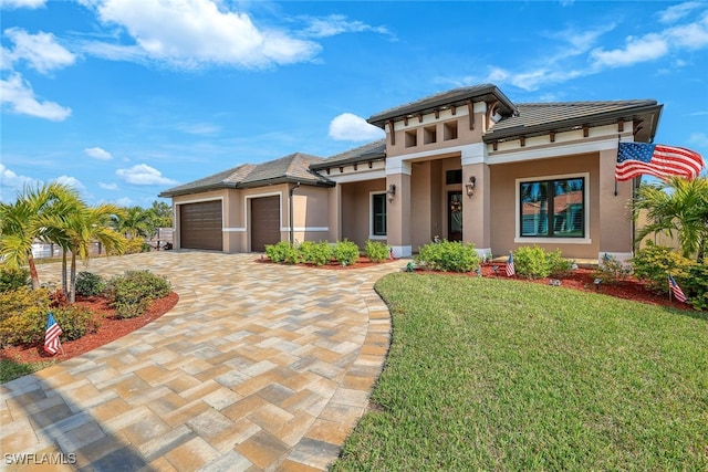 prairie-style home featuring a garage and a front lawn