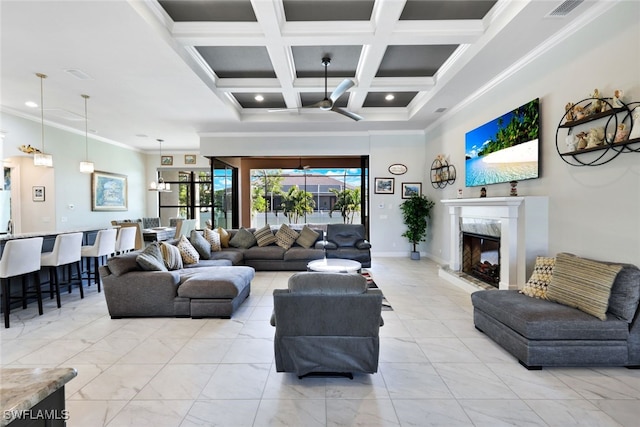 living room with beamed ceiling, a fireplace, ceiling fan, crown molding, and coffered ceiling