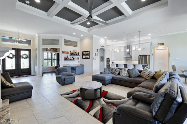 living room with coffered ceiling, indoor bar, ornamental molding, and beverage cooler