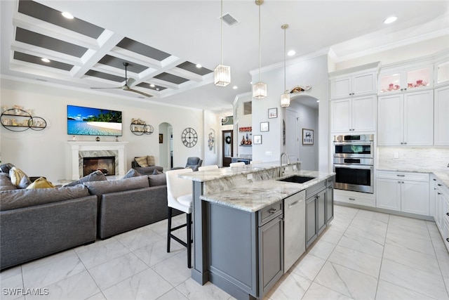 kitchen with sink, white cabinets, beam ceiling, and coffered ceiling