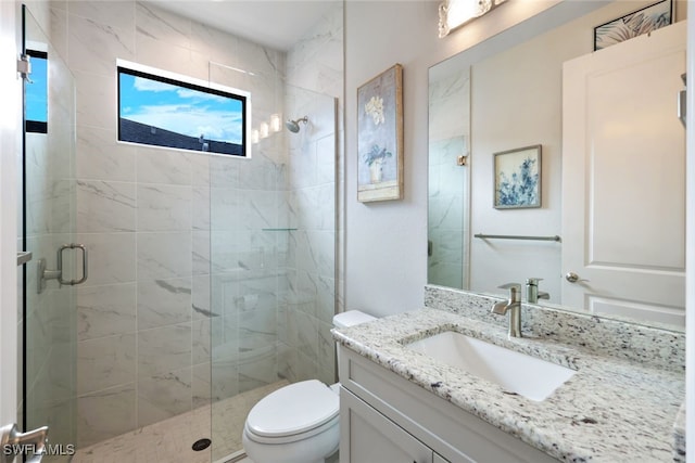 bathroom featuring toilet, an enclosed shower, and vanity