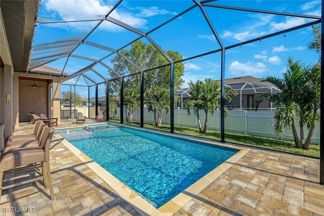 view of pool featuring glass enclosure and a patio area